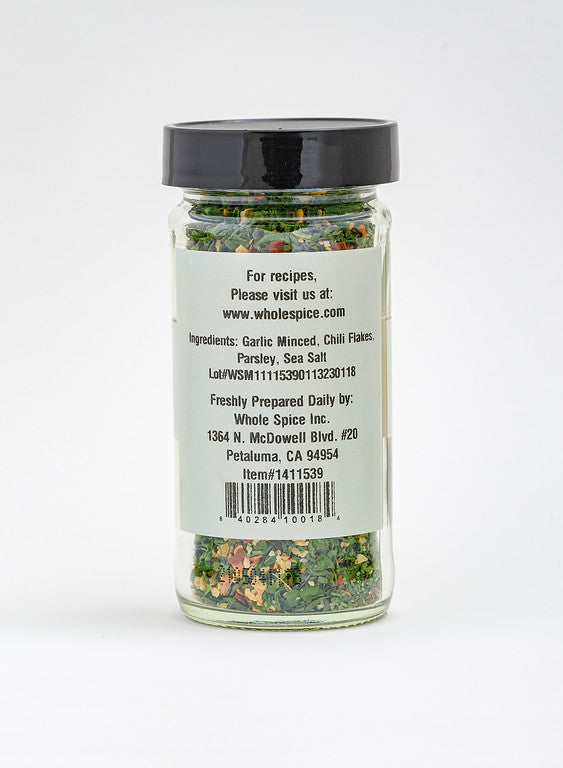 Whole Spice Inc.’s Aglio Olio E Pepperoncino is a clear spice jar with a black lid and back label, featuring a Mediterranean blend of minced garlic, chili flakes, parsley, and sea salt for authentic Italian flavor.