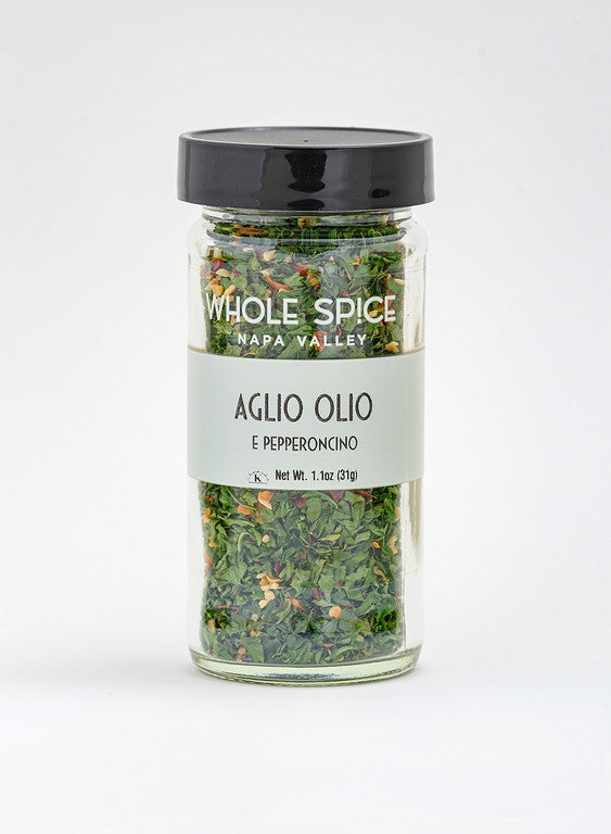 Aglio Olio E Pepperoncino by Whole Spice Inc. is a 1.1 oz (31g) glass jar with a black lid, filled with a Mediterranean blend of dried green and red herbs and spices for classic Italian flavor.