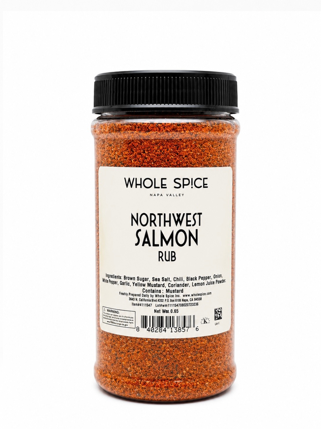 A plastic jar labeled with Whole Spice Inc.’s Northwest Salmon Rub contains a reddish spice blend crafted to enhance cedar plank salmon. The white label on the jar lists ingredients such as brown sugar, sea salt, and spices, while the black lid completes its gourmet look—making it an essential fish seasoning for your kitchen.