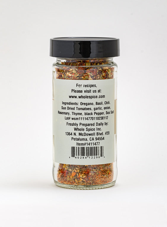 Whole Spice Inc. Pizza Seasoning comes in a clear glass jar with a black lid. This vibrant blend—oregano, basil, chili, sun-dried tomatoes, garlic, rosemary & thyme—is perfect for pasta sauces or as pizza seasoning. Ingredients and contact info on label.