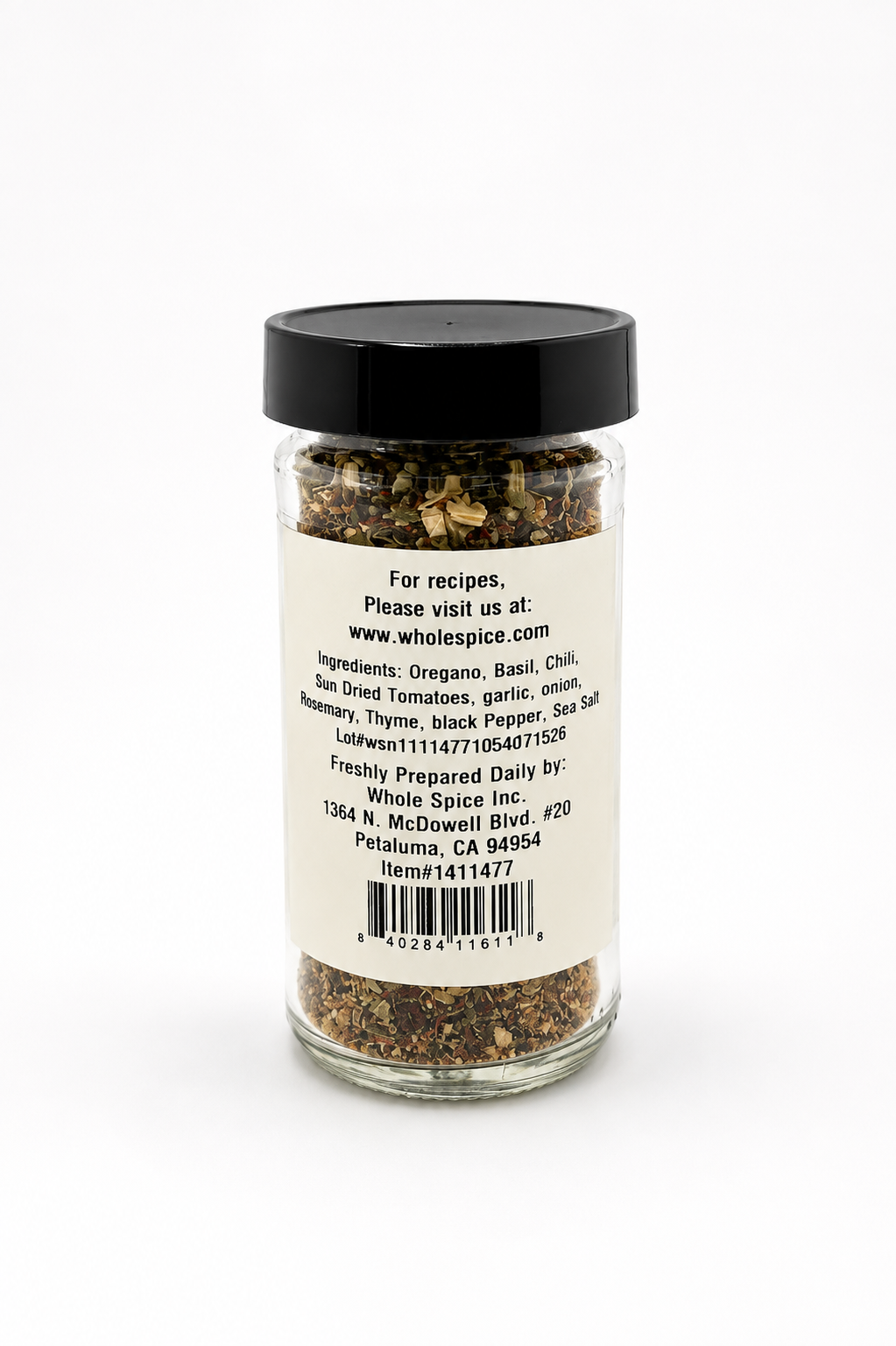 A glass jar with a black lid labeled “Pizza Seasoning” by Whole Spice Inc. contains a blend of mixed spices, including oregano, basil, and chili—ideal for enhancing pasta sauces or adding bold flavor to your pizza. The label also features contact information for Whole Spice Inc.