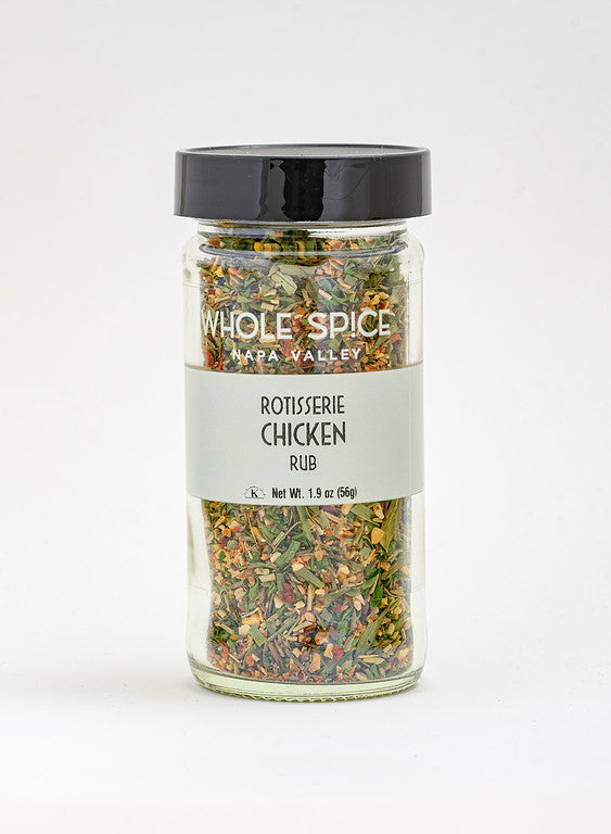 A 1.9 oz (56g) glass jar of Whole Spice Inc. Rotisserie Chicken Rub, with a black lid, contains a colorful blend of dried herbs and spices—perfect for roasted or grilled chicken.