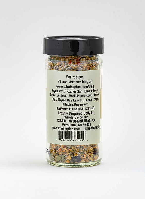 A clear spice jar with a black lid from Whole Spice Inc. holds Turkey Brining Blend—a colorful seasoning of salt, brown sugar, garlic, and herbs. The label provides ingredients plus website, address, and phone number for contact.