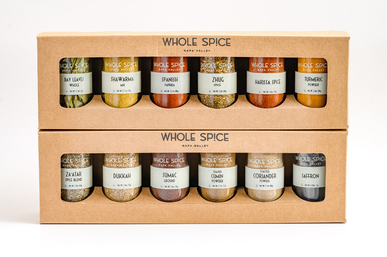 The Whole Spice Middle Eastern Jar Set by Whole Spice Inc. includes twelve jars of assorted spices—like bay leaves, turmeric, sumac, coriander, and saffron—neatly arranged in a kraft paper box.