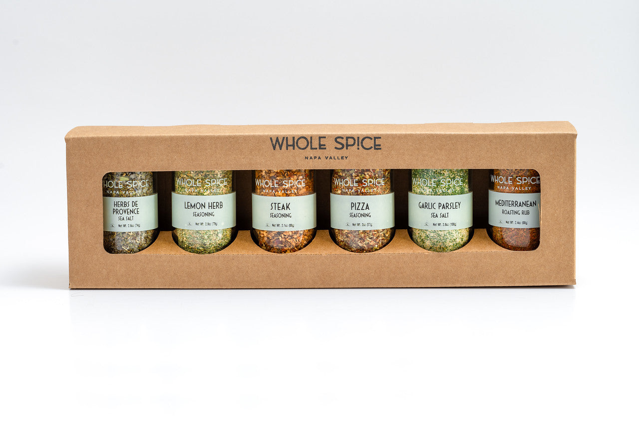 The Whole Spice Mother's Day Roasting Spice Set by Whole Spice Inc. features six spice jars—Herbes de Provence, Lemon Herb, Steak, Pizza, Garlic Parsley, and Mediterranean—in a cardboard holder against a white background.
