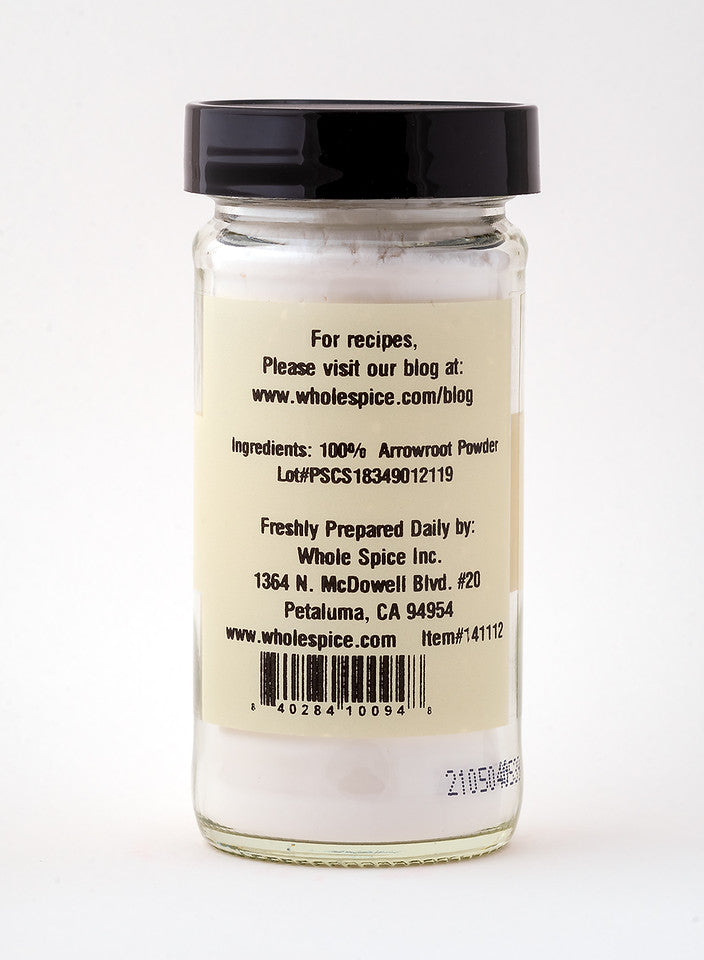 A clear glass jar with a black lid contains gluten-free Arrowroot Powder by Whole Spice Inc. The label lists ingredients, company info, barcode, and a recipes website—ideal as a natural thickening agent.