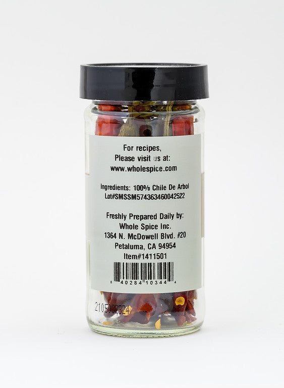 A glass jar of Whole Spice Inc. Chili De Arbol Whole, perfect for spicy salsa, features a black lid and a white label on the back with ingredients, website, and company info in black text.