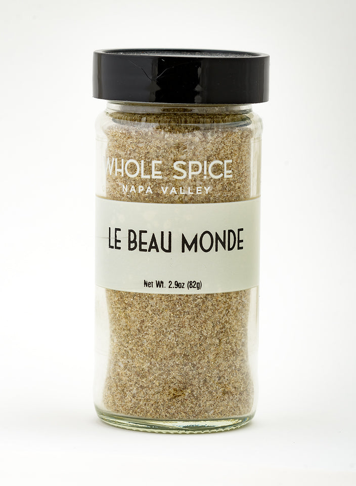 A 2.9 oz (82g) glass jar from Whole Spice Inc., labeled Le Beau Monde, with a black lid, contains a light brown, versatile seasoning ideal for any savory spice blend.