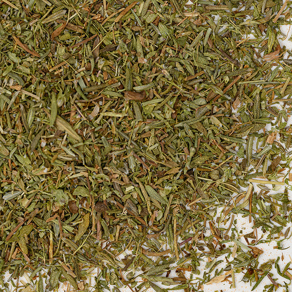 A close-up of Whole Spice Inc. Thyme Leaves shows small, green and brown, finely chopped leaves and stems scattered on a white background—an ideal dried herb for your kitchen pantry.