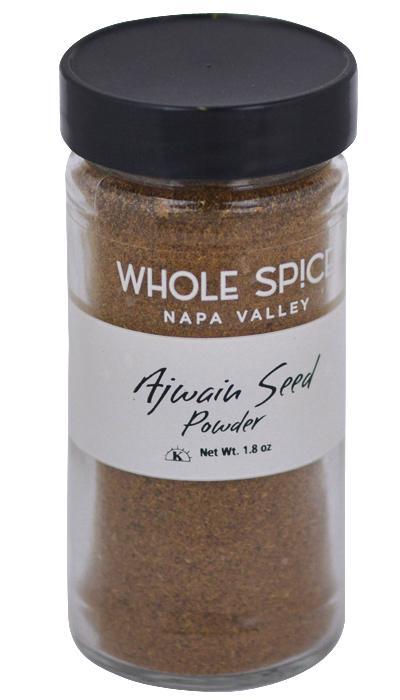 A clear glass jar with a black lid contains brown Ajwain Seed Powder by Whole Spice Inc., Net Wt. 1.8 oz—perfect for Indian cooking.