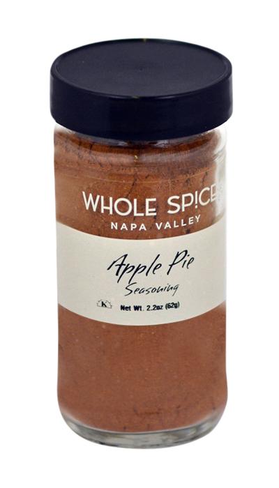 A glass jar with a black lid labeled Whole Spice Inc. Apple Pie Seasoning, Net Wt. 2.2oz (62g), holds a brown spice blend ideal for apple desserts or as a versatile baking and cooking spice.