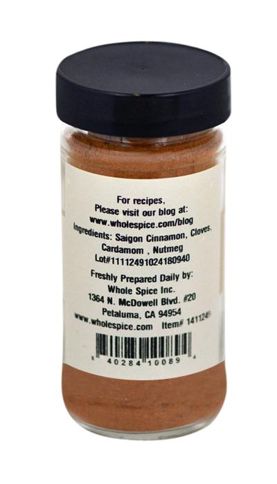 A clear spice jar with a black lid contains Whole Spice Inc. Apple Pie Seasoning—a brown blend of Saigon cinnamon, cloves, cardamom, and nutmeg. Versatile for apple desserts. Label features ingredients, company, and website info.