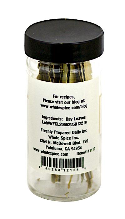 A clear spice jar with a black lid holds Bay Leaves Whole from Whole Spice Inc. The label features ingredients, company info, a barcode, and the Petaluma, CA address—a classic kitchen staple.