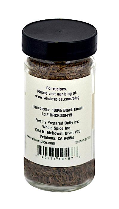 A clear glass jar labeled "Black Cumin Seed" from Whole Spice Inc., filled with whole seeds used in North African and Indian cuisine, includes product info and company contact details on the back.