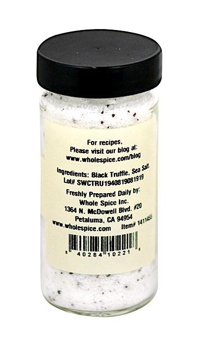 A clear spice jar with a black lid contains Whole Spice Inc.’s Black Truffle Salt—a white, speckled gourmet salt. The label includes ingredients and contact details for Whole Spice Inc. in Petaluma, California.