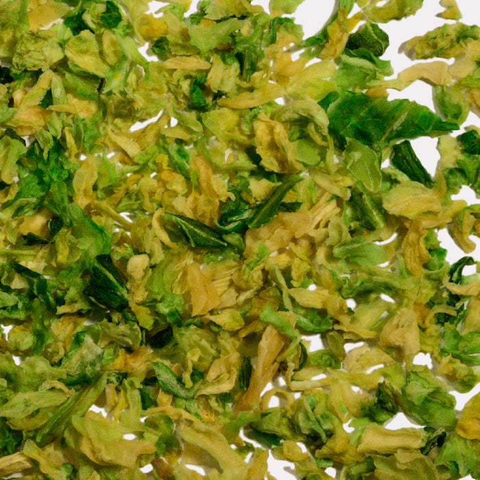 Close-up of Whole Spice Inc. Cabbage Flakes, featuring dried pieces in mixed green and yellow shades with crinkled textures, scattered randomly.