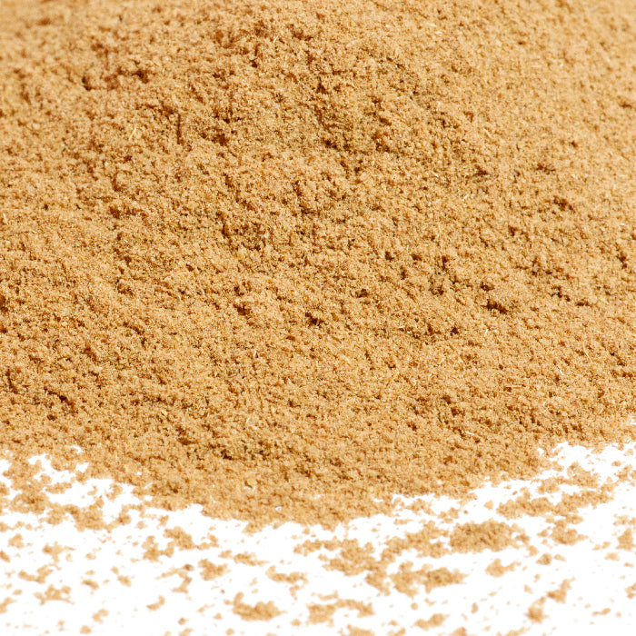 A close-up of Whole Spice Inc. Caraway Seed Powder shows a pile of the light brown powder with some scattered on a white surface.