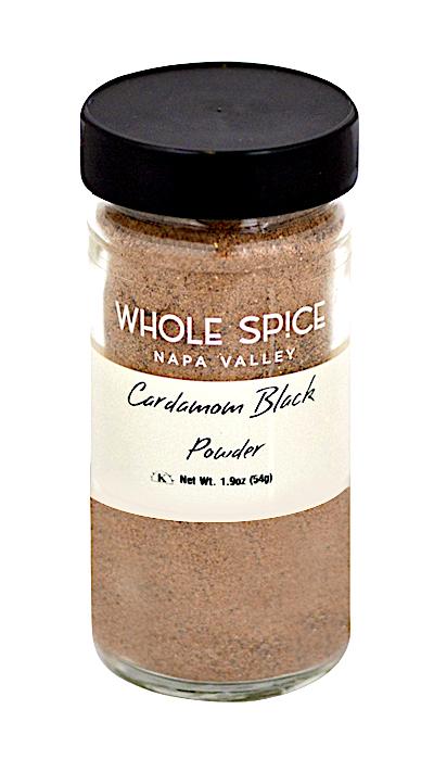 A clear glass jar with a black lid contains Whole Spice Inc. Black Cardamom Powder, a bold, aromatic spice ideal for garam masala blends. Net weight: 1.9 oz (54g).