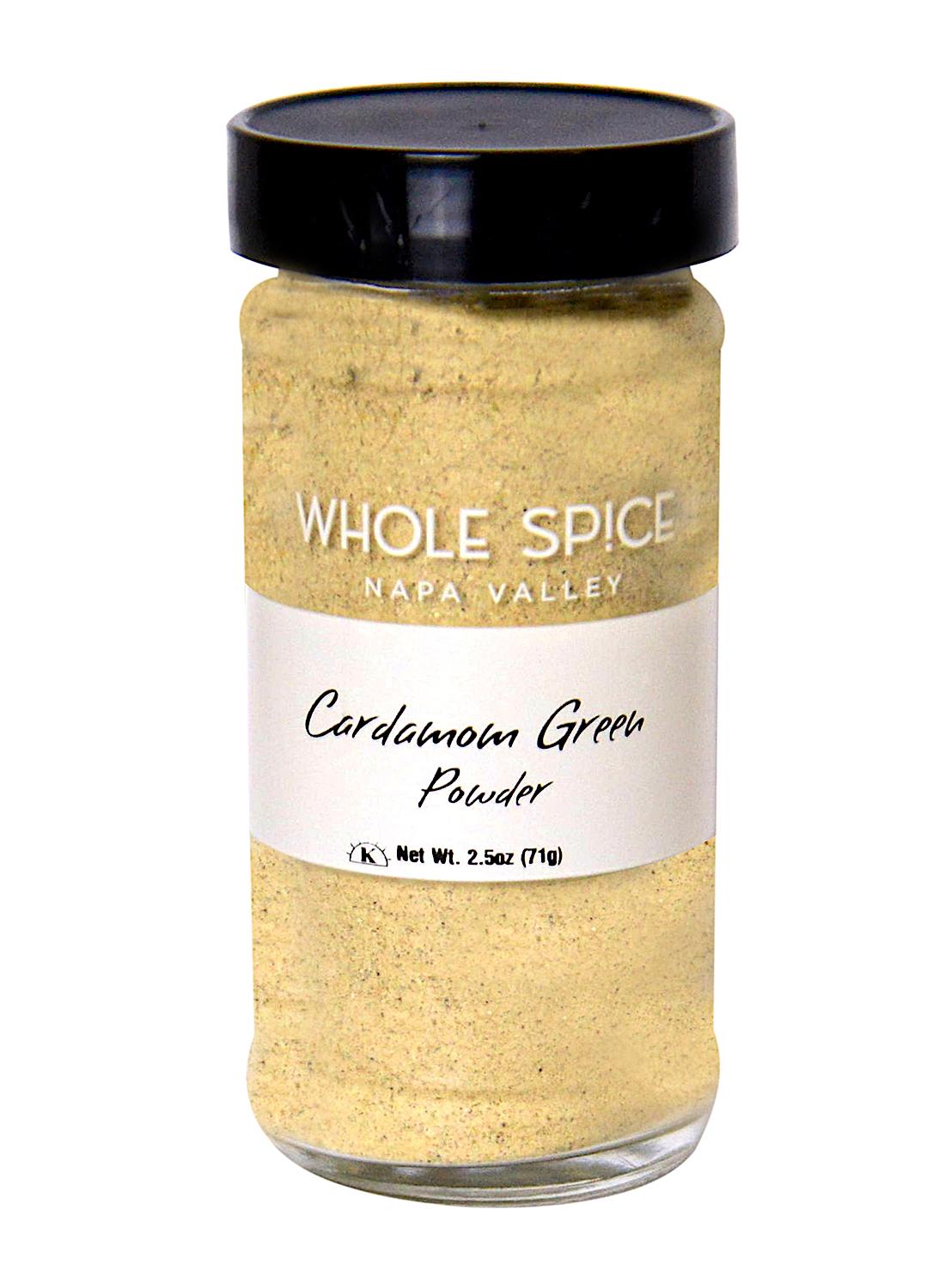 A clear glass jar with a black lid, labeled Whole Spice Inc. Green Cardamom Powder, contains light tan powdered spice with a net weight of 2.5 oz (71g).
