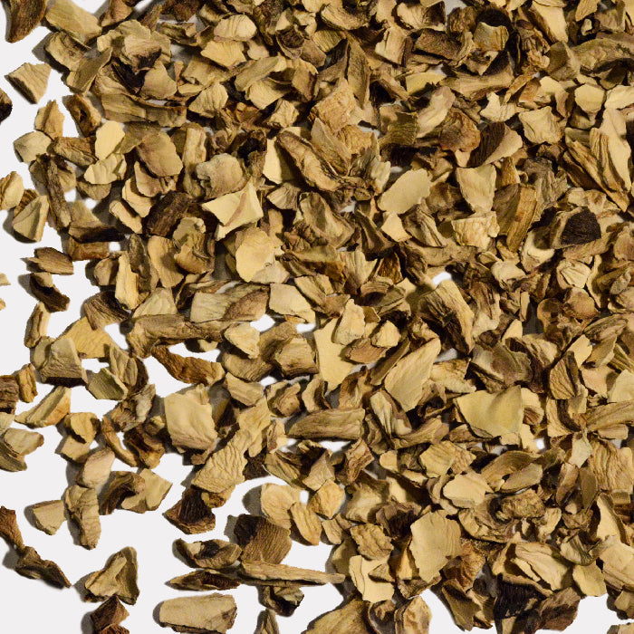 A close-up of scattered Champignon Mushroom Slices by Whole Spice Inc. shows irregular, light brown pieces with darker edges on a white background, highlighting the texture of these popular dried mushrooms.