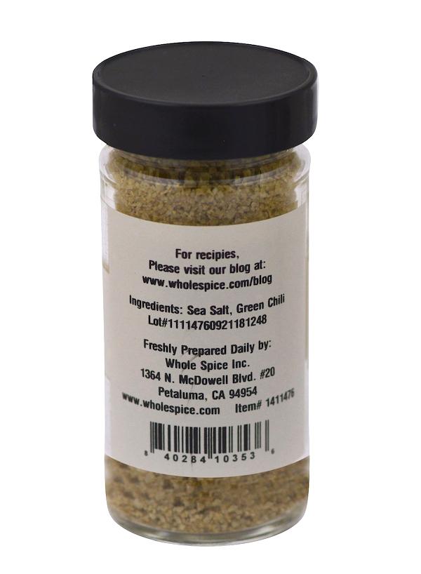 Chili Verde Sea Salt by Whole Spice Inc. comes in a clear jar with a black lid and label listing sea salt, green chili powder, company info, and a recipe website. The finely ground spicy salt inside is light brown.