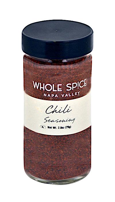 A clear glass jar with a black lid holds Chili Seasoning by Whole Spice Inc., filled with vibrant red chili powder—ideal for adding bold flavor to your favorite chili recipes. Net Wt. 2.8oz (79g).
