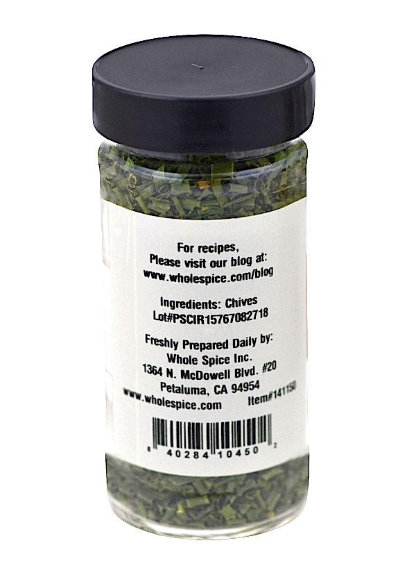 Whole Spice Inc. Chives: Clear spice jar with black lid contains dried chives (Allium family). Label lists ingredients as chives plus company info, barcode, and lot number. Product of Whole Spice Inc., Petaluma, CA.