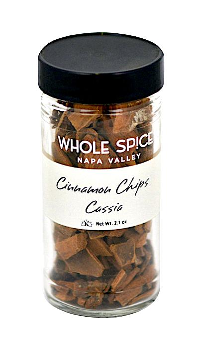 A clear glass jar labeled Whole Spice Inc. Cinnamon Chips Cassia features chunky cinnamon bark chips. The jar has a black lid and a white label with black and brown text. Ideal for adding fresh, premium cinnamon flavor beyond ground spice varieties.