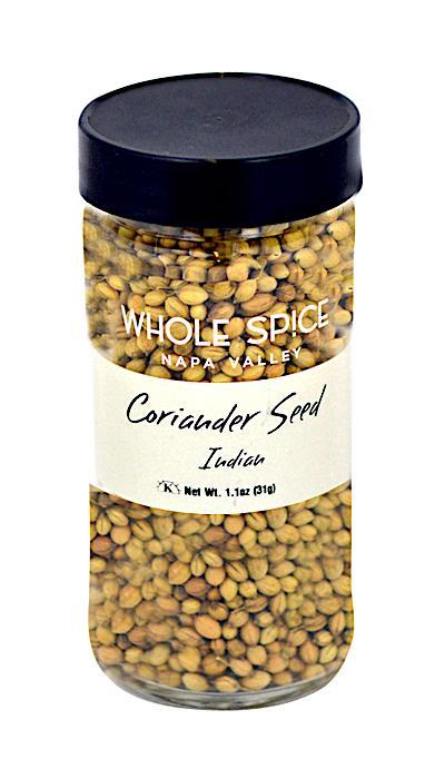 A clear spice jar with a black lid, filled with Whole Spice Inc. Coriander Seed Whole Indian, Net Wt. 1.1oz (31g)—ideal for adding tangy flavor to authentic Indian dishes.