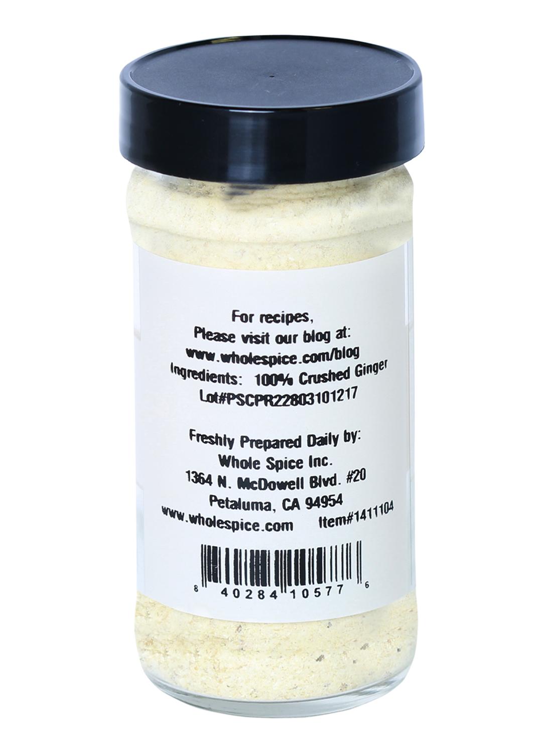 A clear jar labeled "Ginger Crushed" from Whole Spice Inc., with a black lid, ingredient info (100% crushed ginger), contact details, and barcode on the back—perfect for enhancing any curry powder blend.