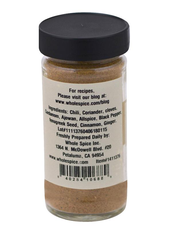A clear spice jar labeled East African Rub by Whole Spice Inc. lists ingredients—chili, coriander, cloves, cardamom, ajwan, allspice—a recipe website, and the company’s Petaluma, CA address.