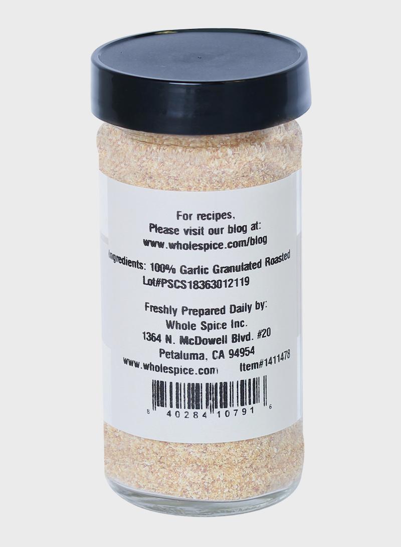 Whole Spice Inc. Garlic Roasted Granulated comes in a clear jar with a black lid, ideal for Mediterranean dishes. The back label lists 100% garlic, shows the Petaluma, CA company address, and features a barcode at the bottom.