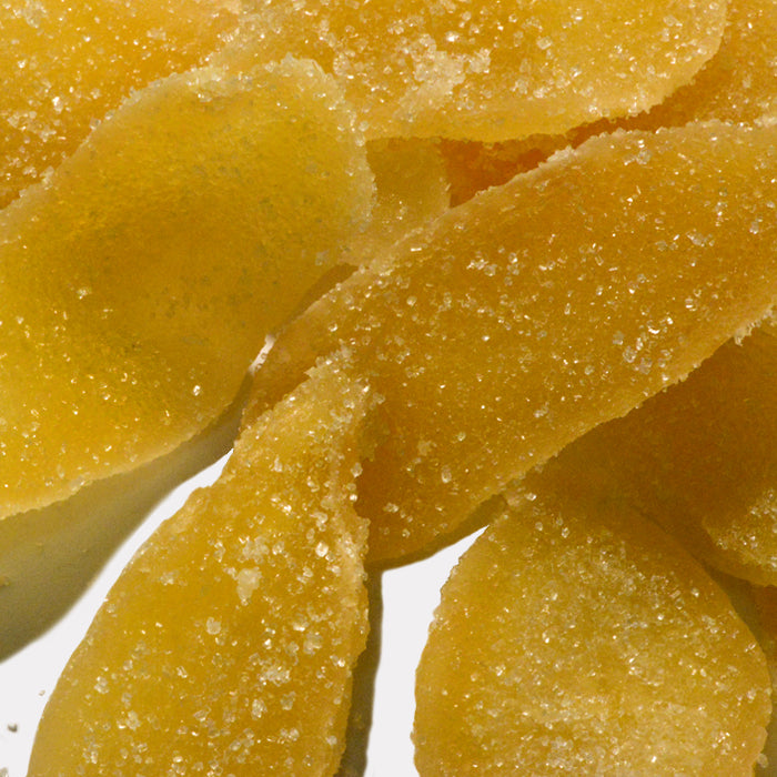 Close-up of Ginger Crystallized by Whole Spice Inc., featuring several sugar-coated slices with a rough, sugary texture and golden yellow color.