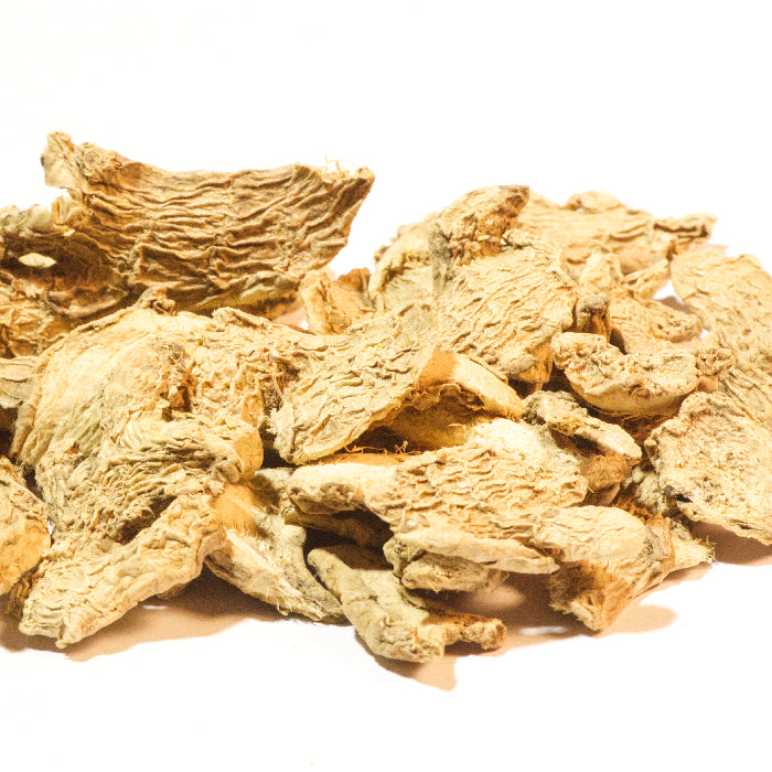 A pile of Whole Spice Inc. Ginger Slices Organic, dried and beige with a slightly curled, textured appearance, displayed on a white background.