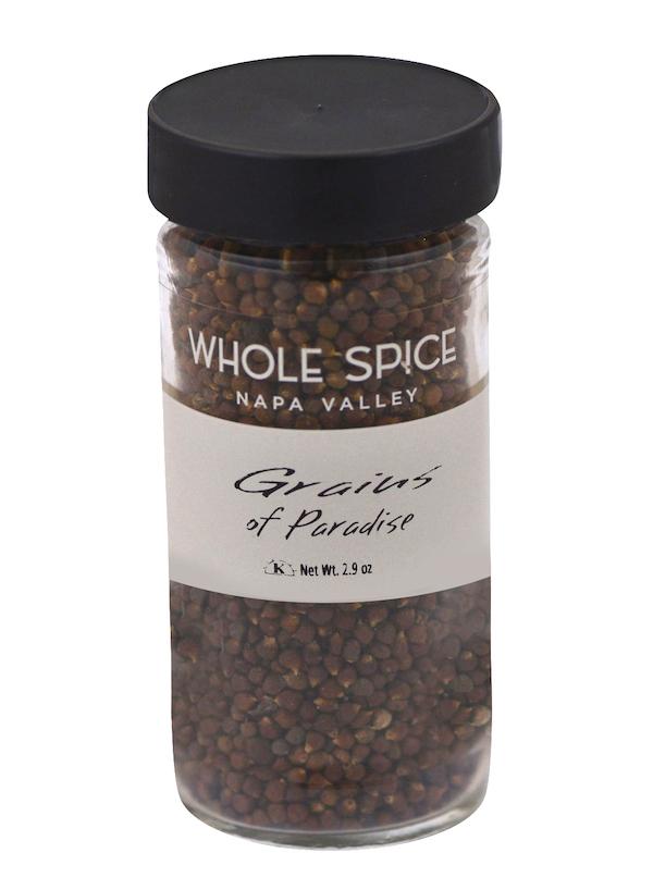 A clear glass jar with a black lid contains small brown Grains of Paradise spice by Whole Spice Inc., Net Wt. 2.9 oz.