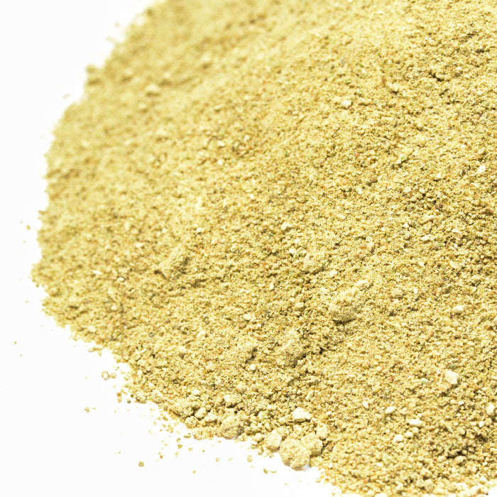 A close-up of Roasted Green Bell Pepper Powder by Whole Spice Inc.—a coarse, light yellowish-brown powder on a white background, perfect as a paprika spice substitute.