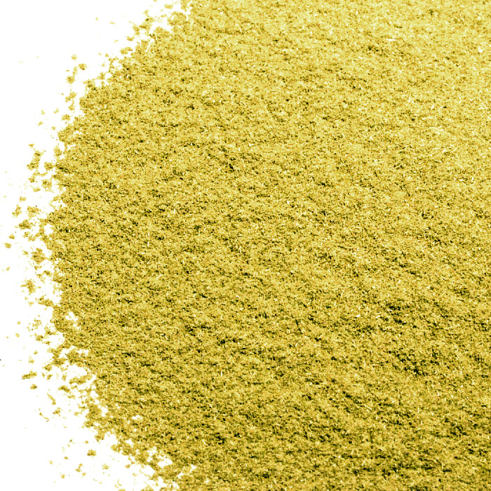 A close-up of Whole Spice Inc. Gumbo Filé, a coarse and granular yellow powder used as a Creole and Cajun thickener, spread on a white surface.