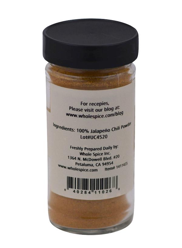 A clear glass jar with a black lid from Whole Spice Inc. holds Jalapeño Red Chili Powder. Its label lists “Ingredients: 100% Jalapeño Chili Powder,” has prep tips, a website, and a barcode at the bottom.