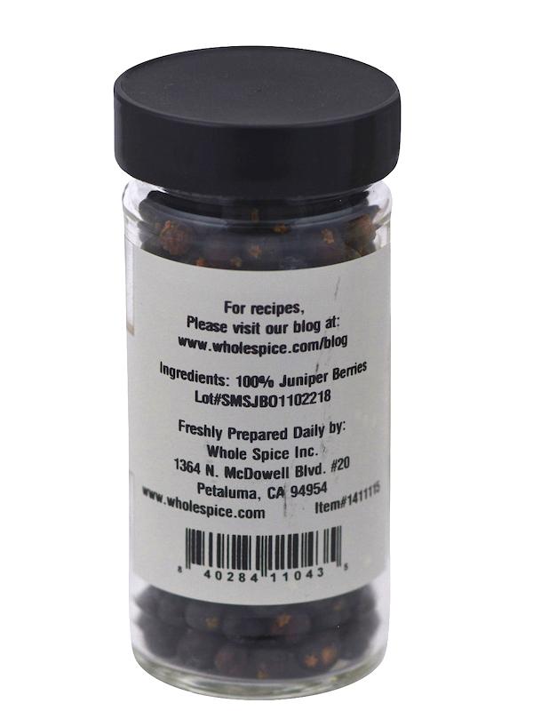 A clear spice jar from Whole Spice Inc. with a black lid contains 100% Juniper Berries, popular in savory blends and Scandinavian dishes. The label shows company info, prep date, and a website for recipes.
