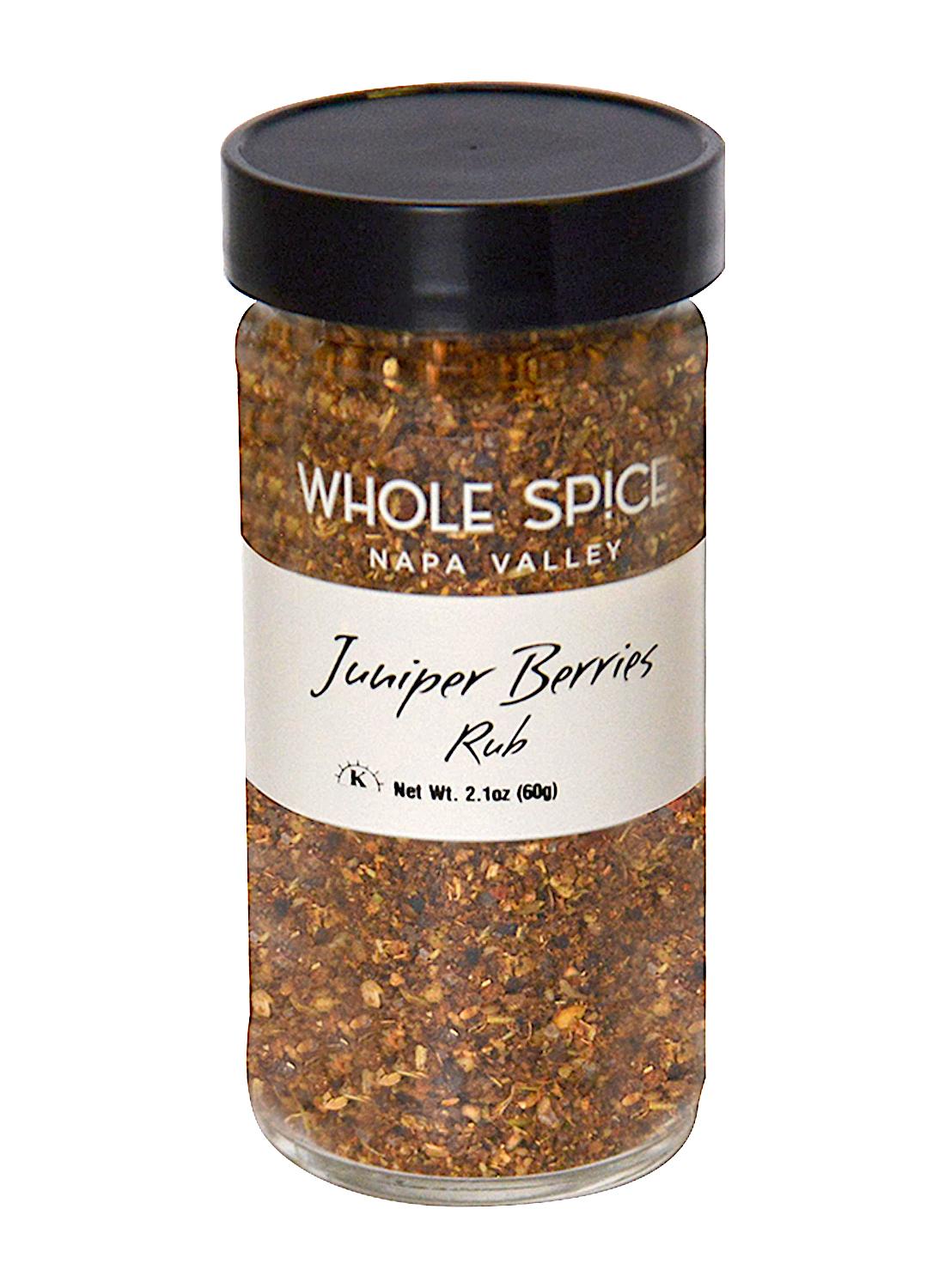 A clear glass jar with a black lid labeled Whole Spice Inc. Juniper Berry Spice Rub. This coarse, brown-red whole rub is ideal for seasoning game meats. Net weight: 2.1 oz (60g).