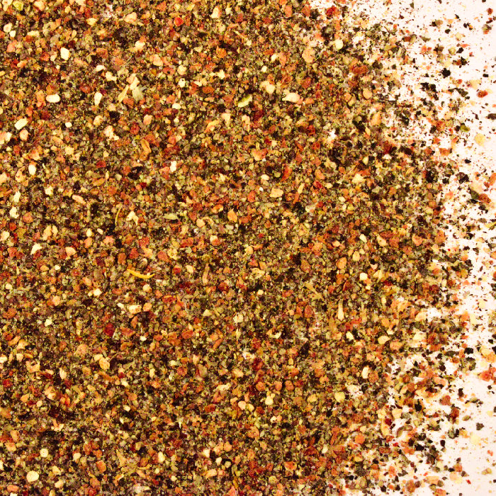 A close-up of Whole Spice Inc.'s Lemon Pepper Salt, a colorful blend with red, green, yellow, and black specks—an all-purpose seasoning ideal for enhancing the flavor of meat and poultry dishes.
