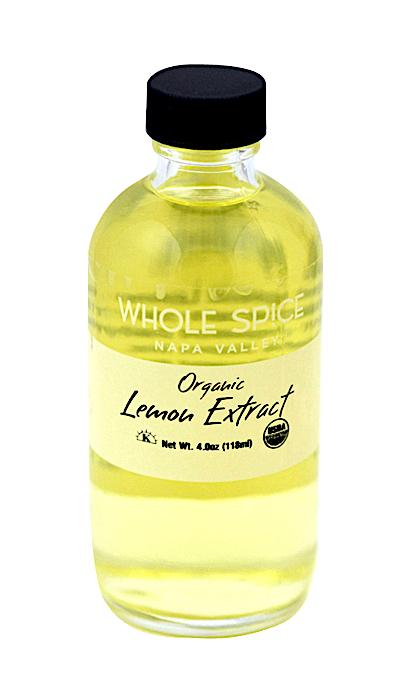 A clear bottle with a black cap, labeled Whole Spice Inc. Lemon Extract Organic, Net Wt. 4 fl oz (118 ml), contains vibrant certified organic citrus extract in yellow liquid form.