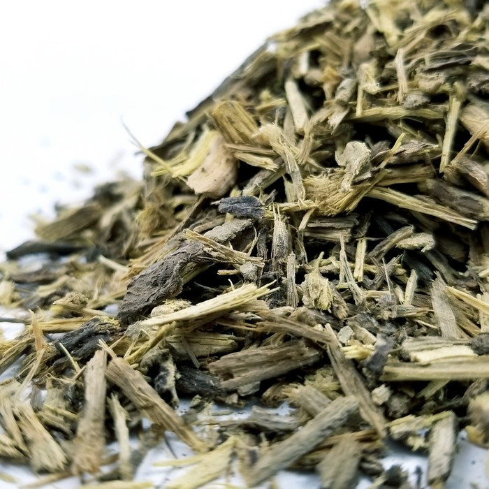 A close-up of Licorice Sticks Chopped by Whole Spice Inc. shows rough, fibrous brown and yellow textures of dried, shredded licorice against a white background.