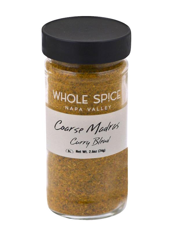 A 2.6 oz (74g) glass jar with a black lid labeled Whole Spice Inc. Madras Curry Coarse, containing a yellow-brown spicy blend inspired by Southern Indian curry spices.