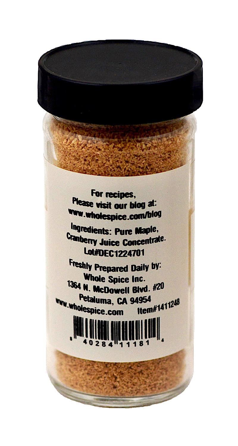 Maple Cranberry Sugar by Whole Spice Inc. comes in a spice jar with a black lid, labeled with pure maple and cranberry juice concentrate. Great for holiday baking, the label features a website, address, and barcode.