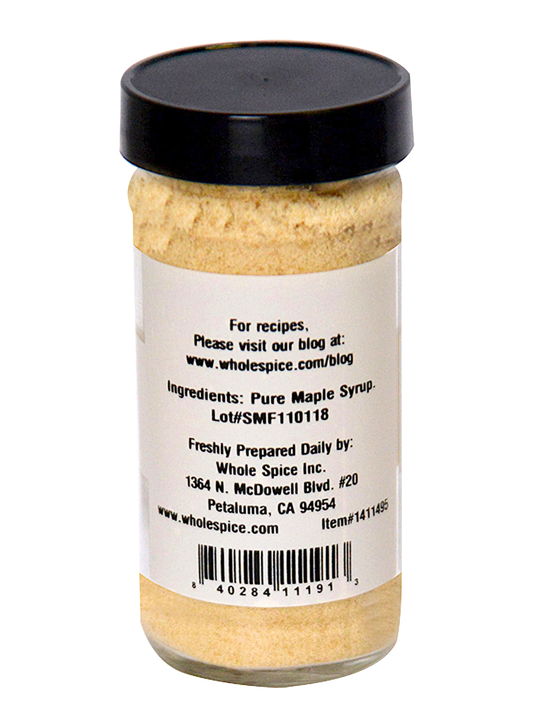 A glass jar with a black lid holds beige Maple Sugar from Whole Spice Inc. The label lists pure maple syrup as the ingredient, describes it as a natural sweetener, and provides contact info plus a recipe website.