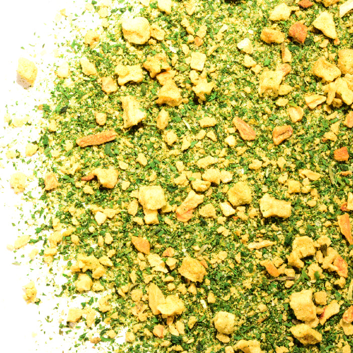 A close-up of Whole Spice Inc.’s Maple Apple Sausage Rub shows green and yellow flakes, dried parsley, and other savory granules—perfect as a flavorful seasoning or versatile meat rub.