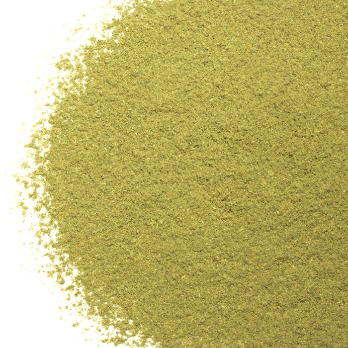 A close-up of finely ground Marjoram Powder Organic by Whole Spice Inc., unevenly spread on a white background. Its dry, smooth texture with tiny granules is ideal for adding organic flavor to your dishes.