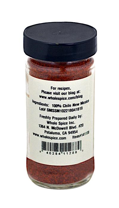 Whole Spice Inc. New Mexico Chili Powder comes in a clear jar with a black lid, filled with vibrant red powder. The label lists 100% Chile New Mexico and provides the manufacturer's contact—ideal for Mexican dishes.