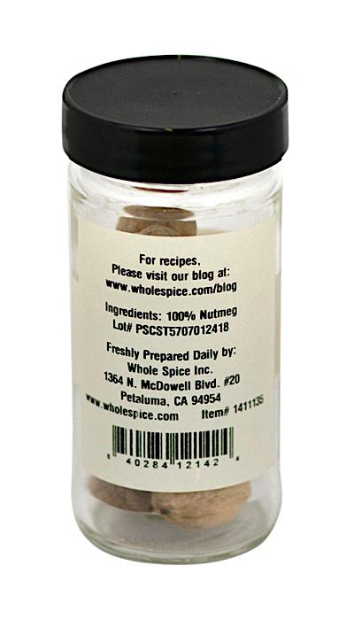 A clear jar labeled Nutmeg Whole by Whole Spice Inc. holds whole nutmeg (100% nutmeg), ideal for sweet or savory recipes. Label includes company address, lot number, website, barcode; jar topped with a black lid.